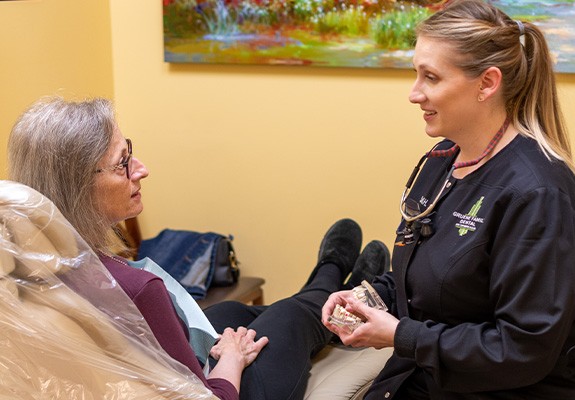 Dental team member talking to patient in dental chair