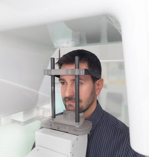 Male patient positioned in CBCT machine, ready for scan