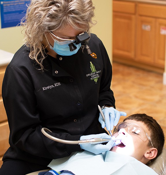 Dental hygienist cleaning patient's teeth