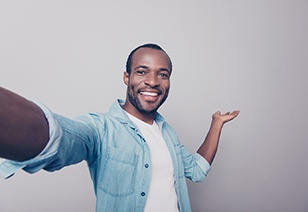man taking a selfie and smiling after investing in his smile