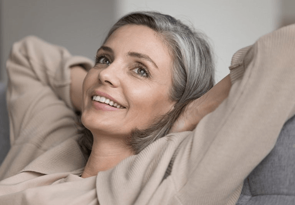 a woman smiling with her new dentures