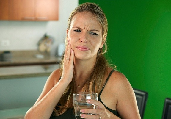 Woman in pain holding cheek