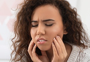 Woman with toothache holding cheeks