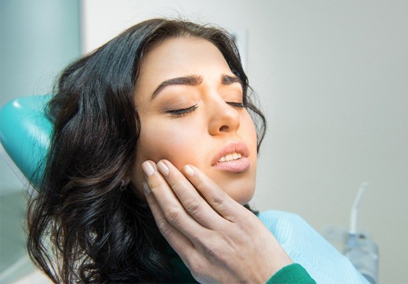 Woman in pain holding jaw