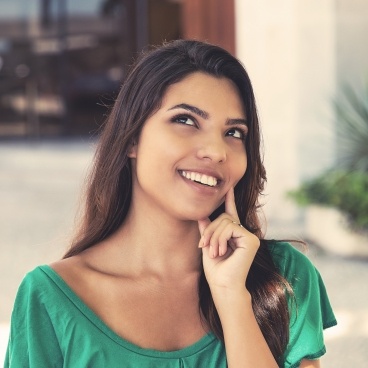 Woman showing off beautiful smile after Invisalign treatment