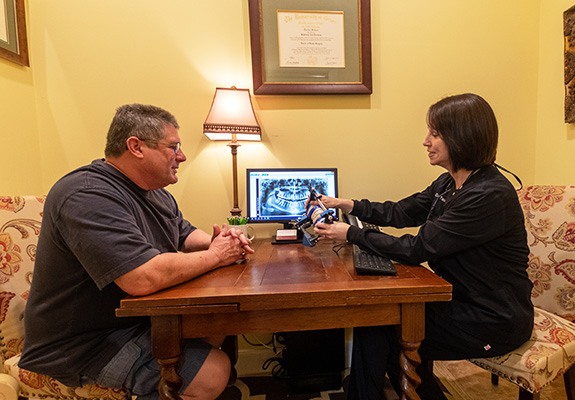 Dentist and patient discussing dental implants in consultation room