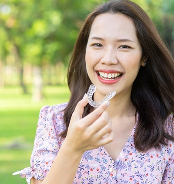 A female teenager preparing to insert her Invisalign in New Braunfels 