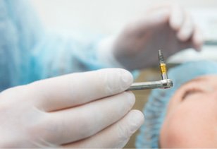 dentist holding implant 