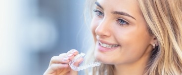 Woman placing an Invisalign tray