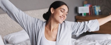 Woman waking feeling rested thanks to sleep apnea therapy