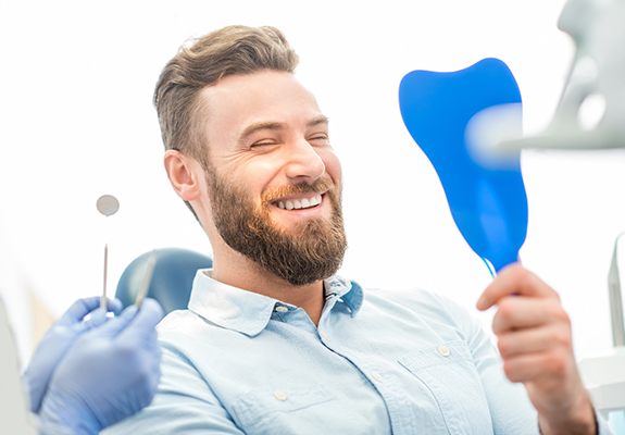 Man admiring his new veneers in New Braunfels