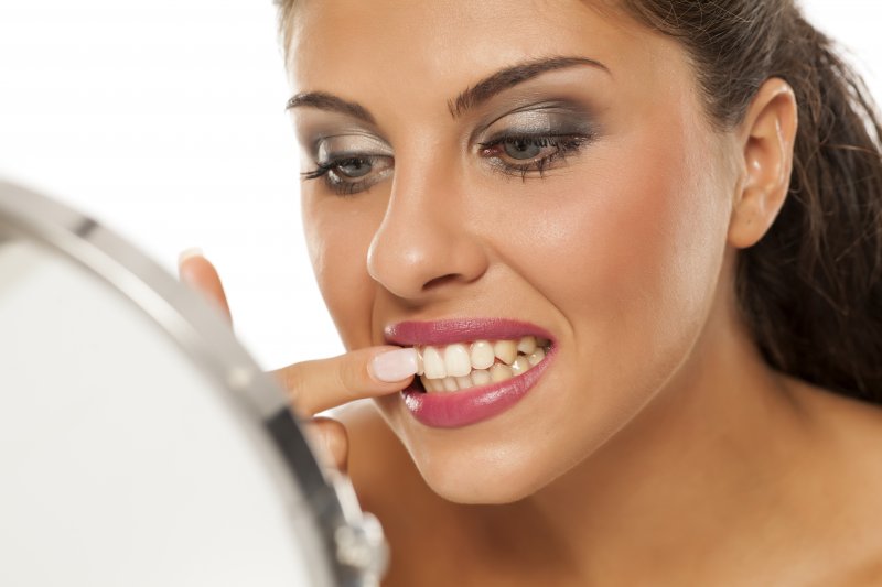 young woman picking between teeth